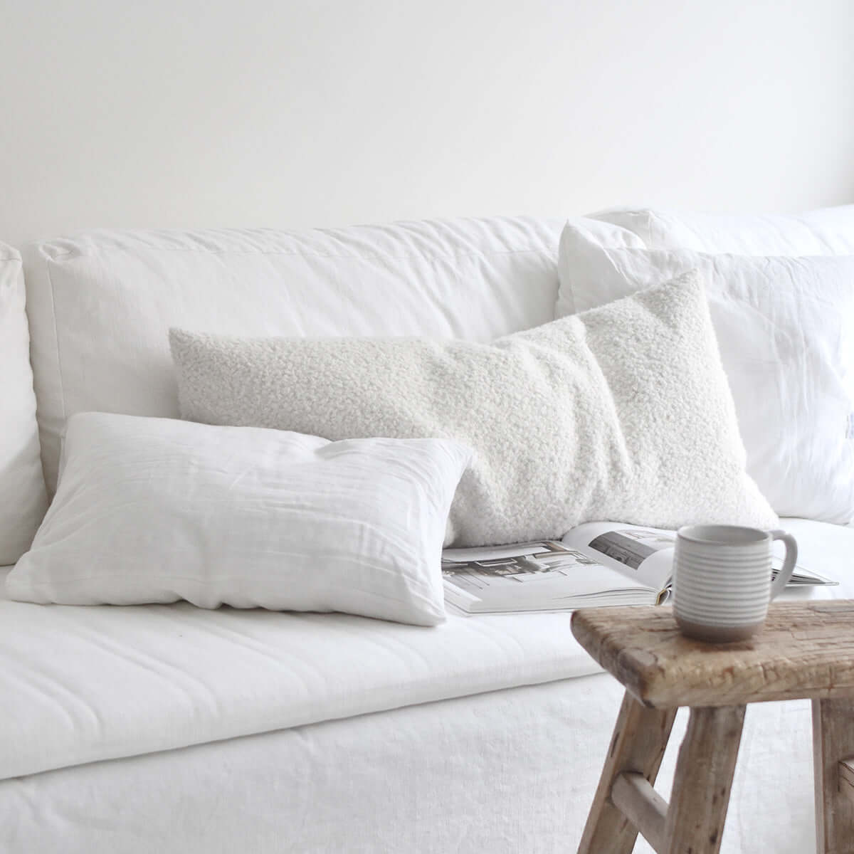 wit interieur met witte linnen kussens op de bank